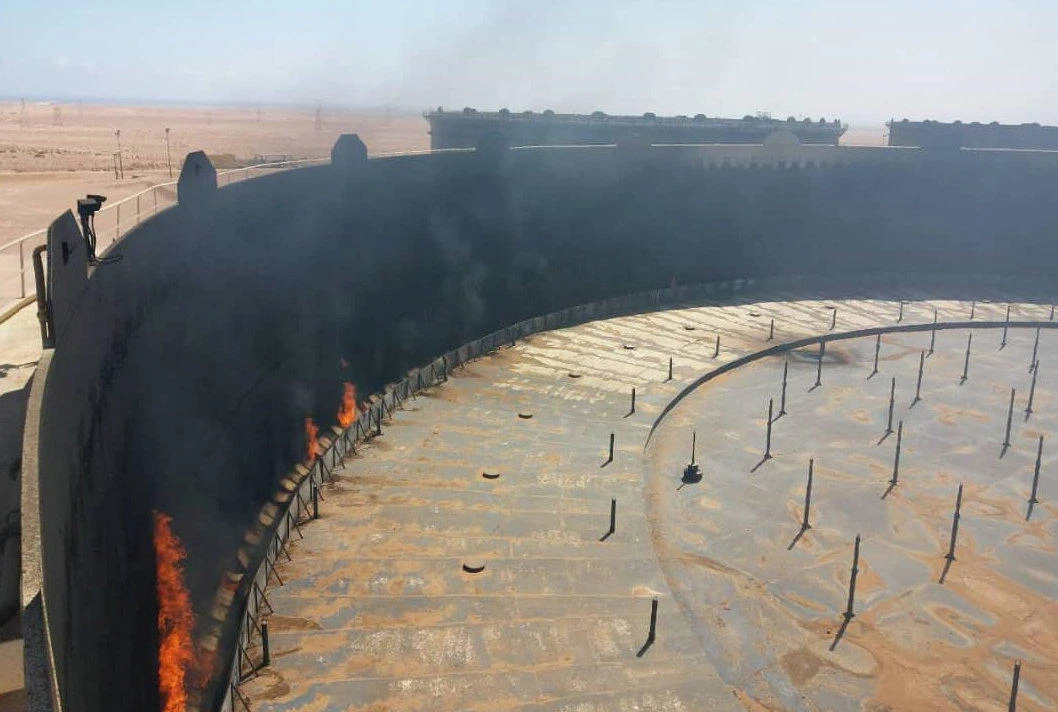 Smoke and flame rise from an oil storage tank that was set on fire amid fighting between rival factions at Ras Lanuf terminal in Libya. (National Oil Corporation via Reuters)