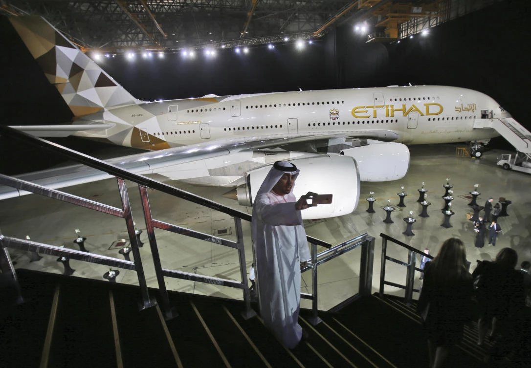 In this Thursday, Dec. 18, 2014, file photo, an Emirati man takes a selfie in front of a new Etihad Airways A380 in Abu Dhabi, United Arab Emirates. (AP/Kamran Jebreili, File)
