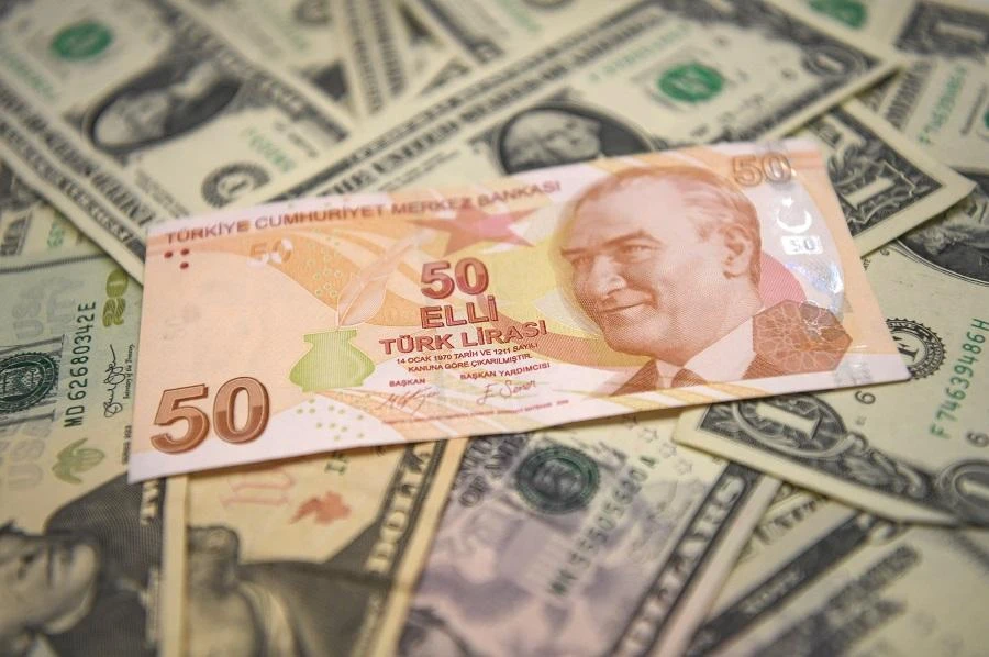 A picture taken in Istanbul on May 23, 2018 shows Turkish lira and US dollars banknotes. (AFP)