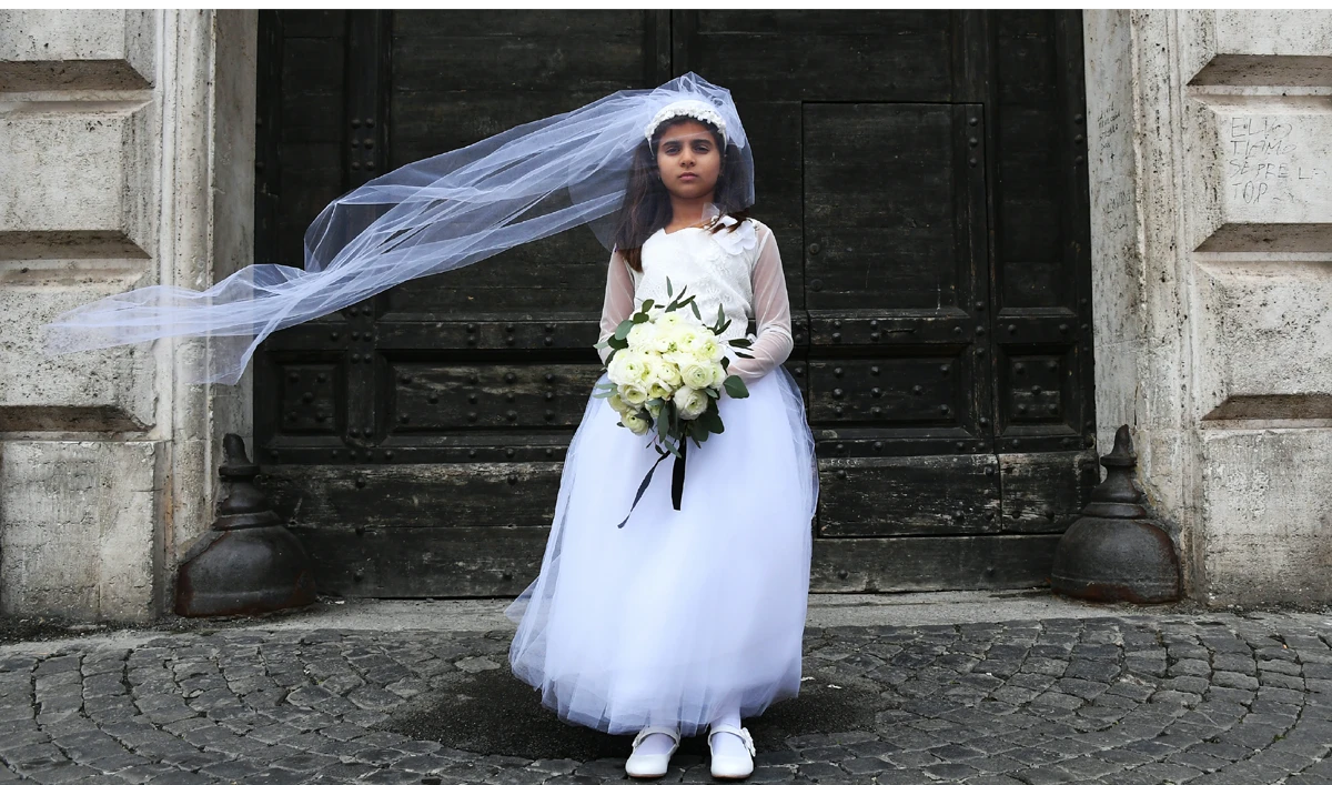 In this file photo, a young actress plays the role of Giorgia, 10, forced to marry Paolo, 47, during a happening organized by Amnesty International to denounce child marriage in Rome, on Oct. 27, 2016. (GABRIEL BOUYS/AFP)