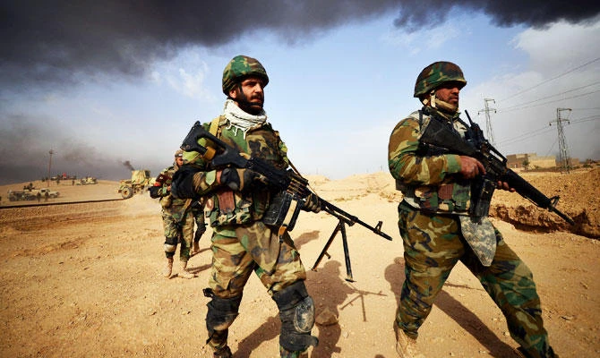 Shi'ite Popular Mobilization Forces (PMF) carrying their weapons, advance towards the city of Al-Qaim. (REUTERS)