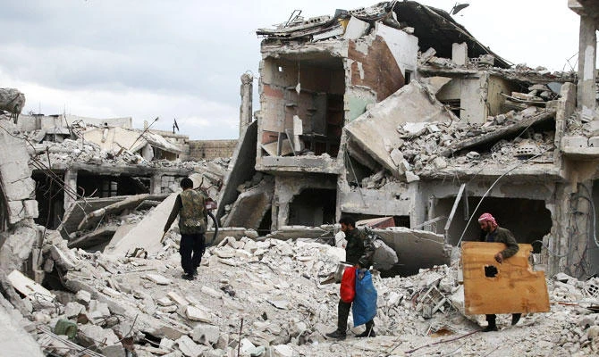 People walk on rubble of damaged buildings in the besieged town of Douma, Eastern Ghouta, in Damascus, Syria, in this March 30, 2018 file photo. (REUTERS)