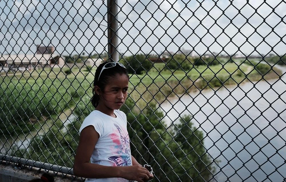 A young girl waits with her family along the border bridge after being denied entry into the Texas city of Brownsville which has become dependent on the daily crossing into and out of Mexico on June 25, 2018 in Brownsville, Texas.(File photo: AFP)