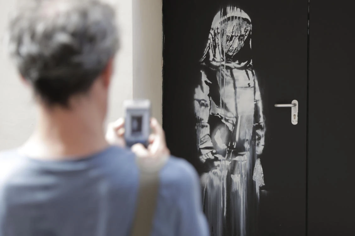 New ‘Banksy’ mural of veiled woman in mourning appears next to Bataclan in Paris