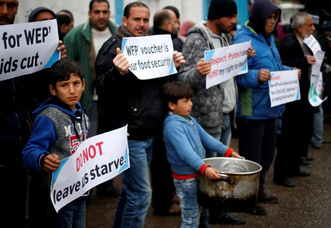 Palestinians hold signs during a protest against aid cuts, outside United Nations’ offices in Gaza City. US President Donald Trump has vowed to slash funding for the UN Relief and Works Agency unless there are political compromises by the Palestinian leadership. (Reuters)