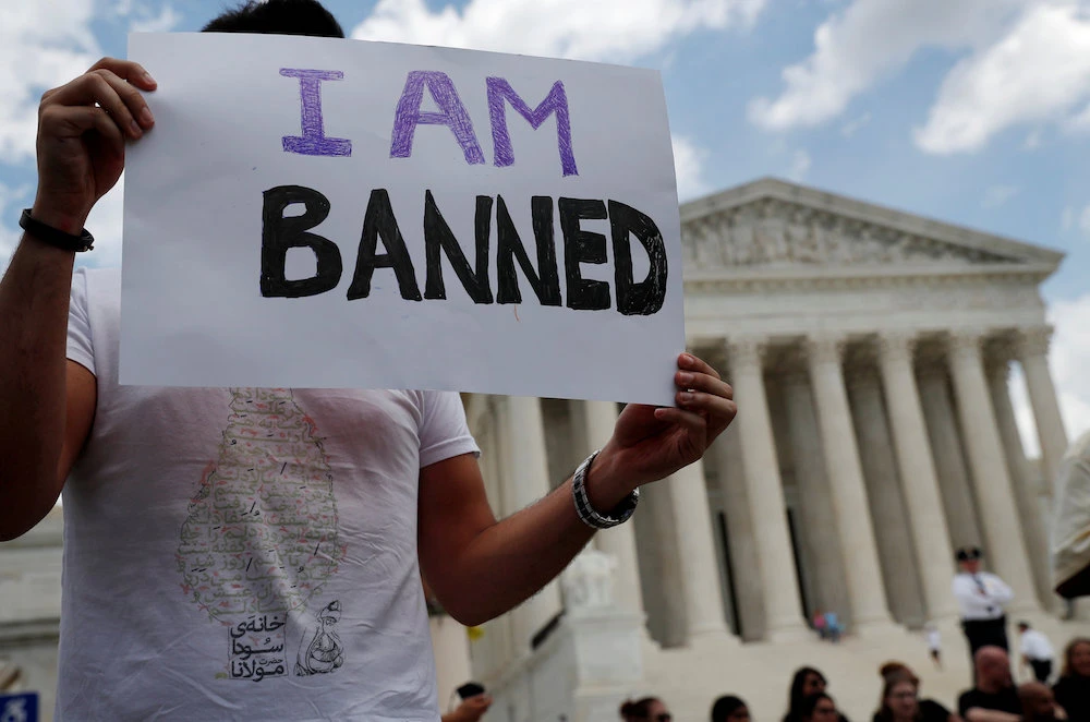 Mehrad Ansari of Iran holds a sign outside of the US Supreme Court after US President Trump’s travel ban was upheld in Washington, US. Ansari and his sister both attend university in the US and now may not go home to see their family in Iran if they want to be able to return to the US. (Reuters)