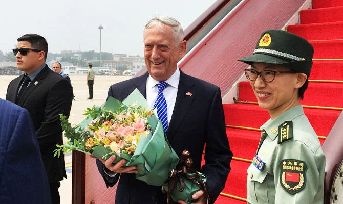 US Defense Secretary Jim Mattis receives a bouquet upon arrival at an airport in Beijing, China on Tuesday. (REUTERS)