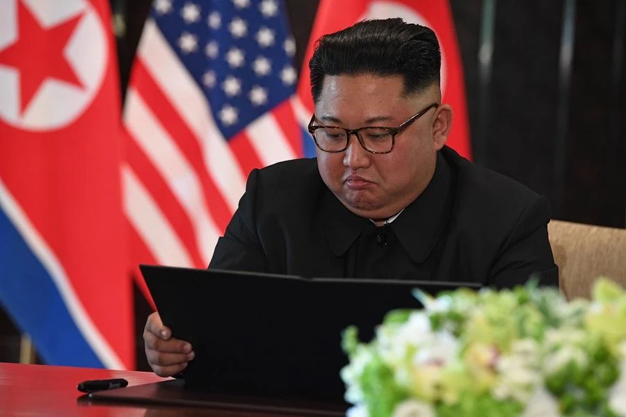 North Korea's leader Kim Jong Un looks at his document at a signing ceremony with US President Donald Trump (not pictured) during their historic US-North Korea summit, at the Capella Hotel on Sentosa island in Singapore on June 12, 2018. (AFP)