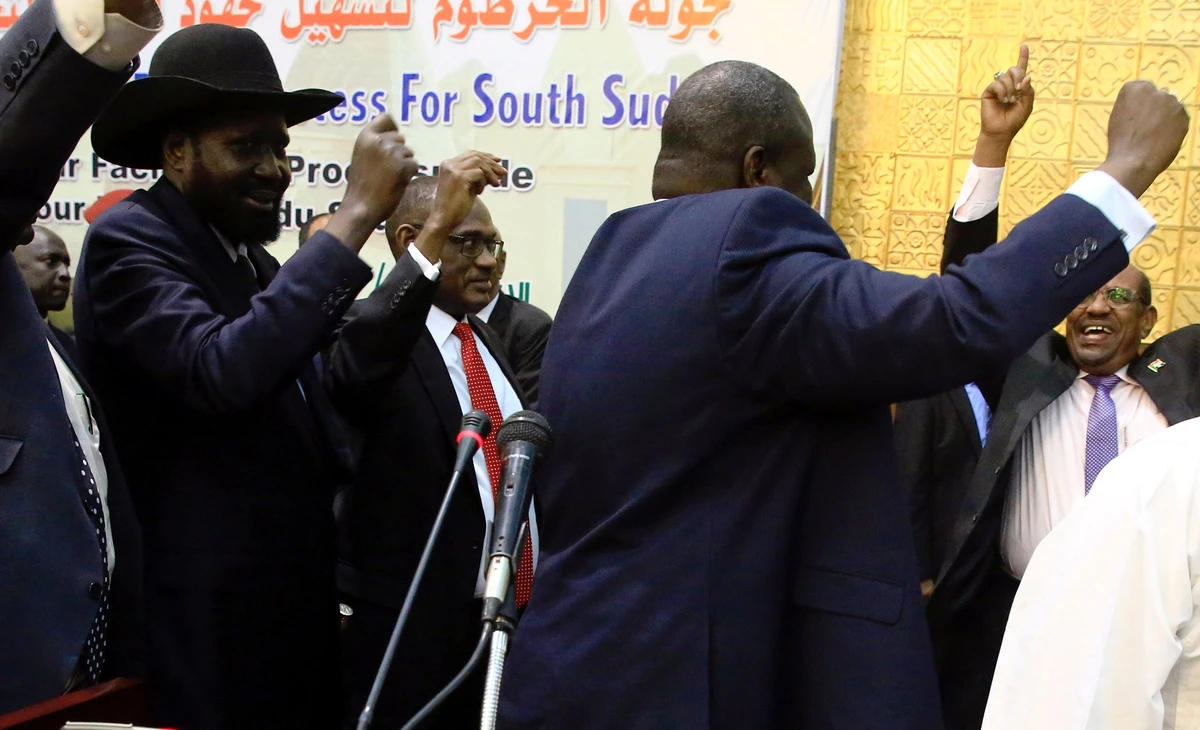 South Sudan's President Salva Kiir and South Sudan rebel leader Riek Machar dance during a South Sudan peace meeting, in Khartoum. (AFP)