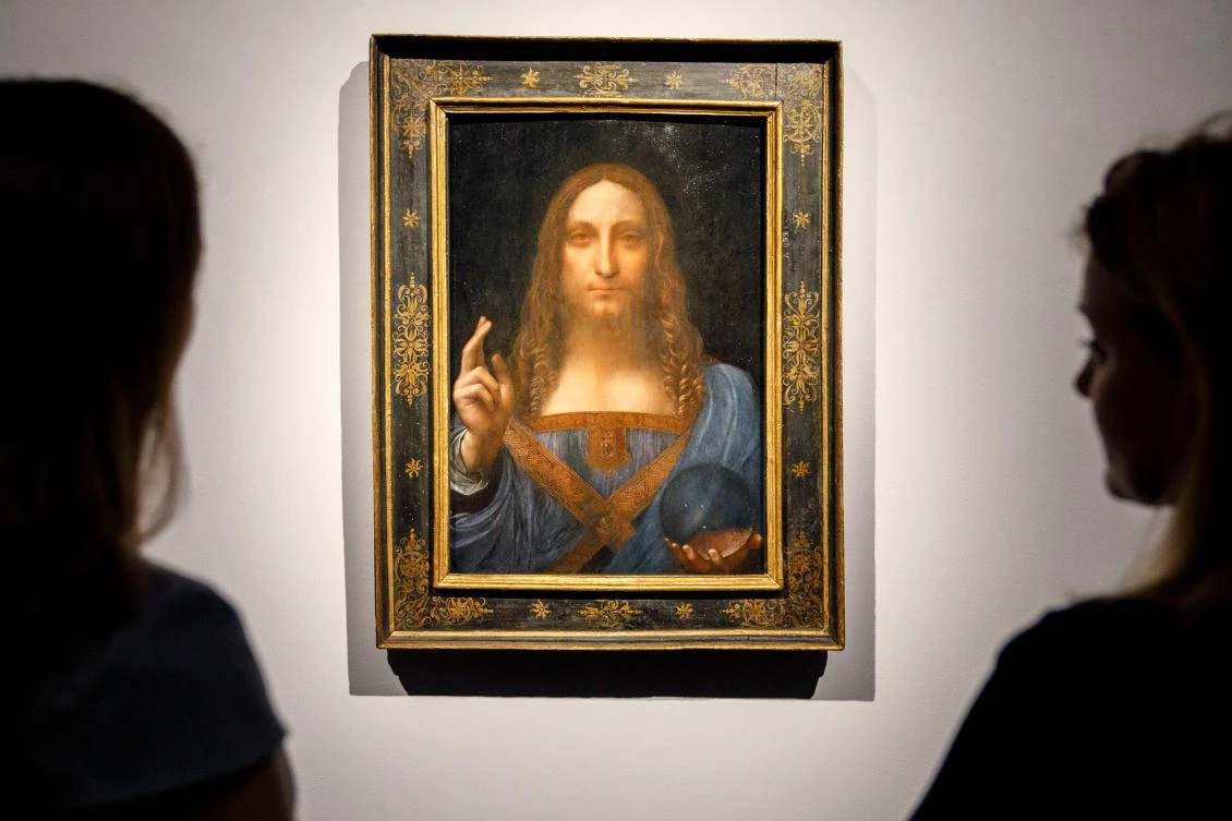 In this file photo taken on October 24, 2017 Christie’s employees pose in front of a painting entitled Salvator Mundi by Italian polymath Leonardo da Vinci at a photocall at Christie’s auction house in central London. (AFP)