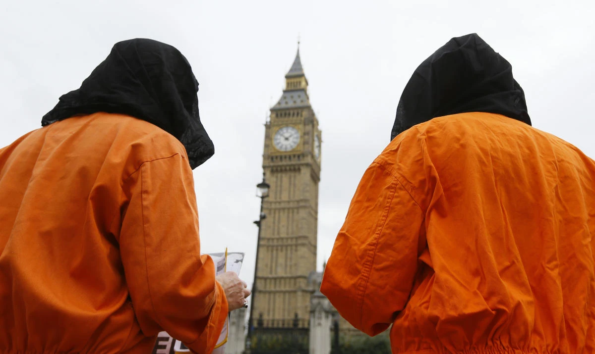 In this file photo dated Wednesday, Oct. 15, 2014, protesters wearing suits and masks protest against the Guantanamo Bay detention camp, in Parliament Square in London, with Big Ben's clock tower in background, Wednesday, Oct. 15, 2014. (AP)