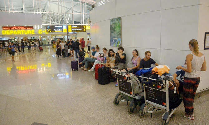 Passengers are seen waiting for flights outside the International Terminal at Ngurah Rai Airport after some flights were cancelled or rescheduled following an eruption of Mount Agung volcano in Bali, Indonesia, on June 28, 2018 . (Antara Foto/Wira Suryantala/via REUTERS)