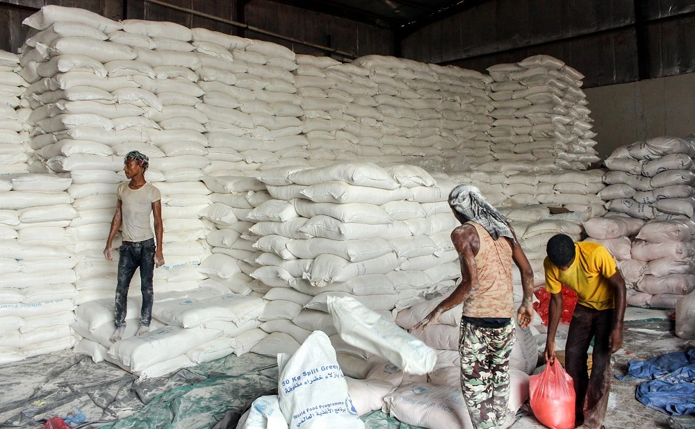 Yemenis distribute sacks of food aid to be given to displaced people who fled battles in the Red Sea province of Hodeida and are now living in camps in the northern district of Abs, under control by the Iranian-backed Houthi in Hajjah province, on June 24, 2018. (File photo: AFP)