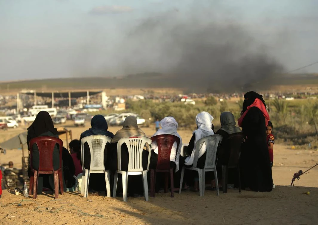 Photo showing Palestinian Women watch confrontations between protesters and Israeli forces east of Gaza City, June 29, 2018. (AFP)
