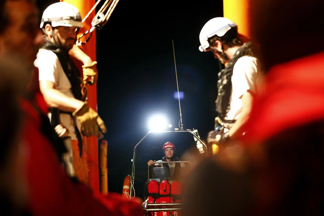 A member of the NGO Proactiva Open Arms as crew from SOS Mediterranee NGO and Doctors Without Borders bring medical supplies from the Aquarius rescue vessel on June 24 in the open sea about 50 miles from Libya. (AFP)