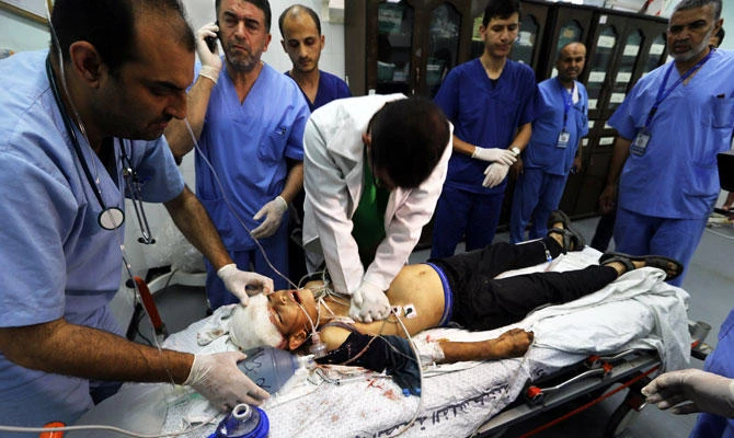 Doctors and medics try to resuscitate 14-year-old Palestinian boy Yasser Abu Al-Naja, who died later after he was shot by Israeli forces during a protest at the Israel-Gaza border, at a hospital in the southern Gaza Strip on Friday. (REUTERS)