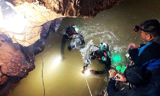 This handout photo taken on June 28, 2018 and released by the Royal Thai Navy SEAL on June 29, 2018 shows a team of Royal Thai Navy SEAL divers inspecting the water-filled tunnel in the Tham Luang cave during a rescue operation for the missing children's football team and their coach in Chiang Rai province. (AFP)
