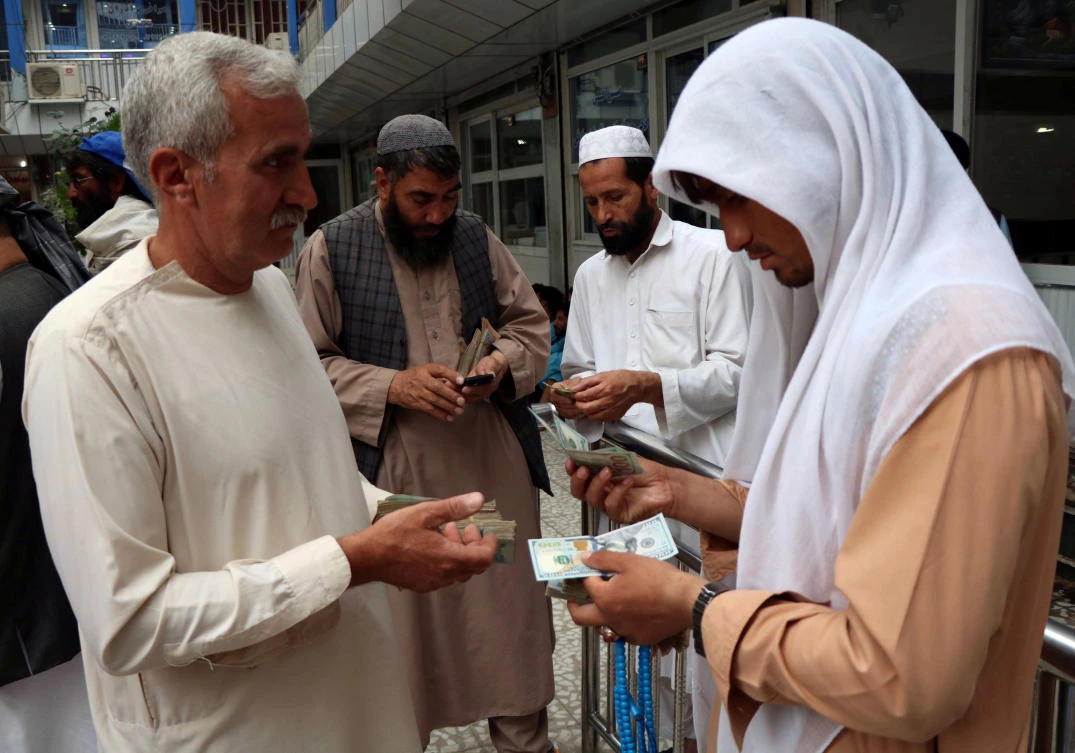Afghan money changers gather to deal with foreign currency at a money change market in Herat province. As much as $2 million to $3 million dollars cross the porous borders of the western provinces of Herat, Farah and Nimruz into Iran every day. (Reuters)