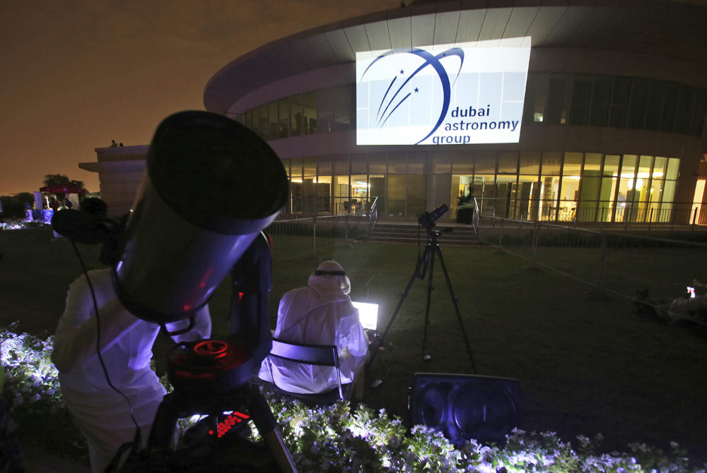 A man watches the lunar eclipse through a telescope at the Al Thuraya Astronomy Center in Dubai, United Arab Emirates, on July 27, 2018. (AP Photo/Kamran Jebreili)