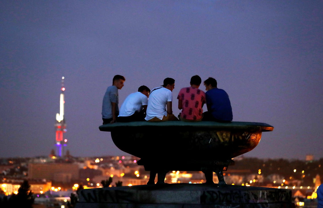 Clouds obscure the view for people sitting on a statue to see the lunar eclipse in Prague, Czech Republic, July 27, 2018. (REUTERS/David W Cerny)