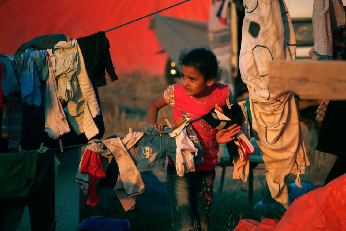 A displaced Syrian child from the Daraa province fleeing shelling by pro-government forces waits in a makeshift camp to cross the Jordanian border, near the town of Nasib, southern Syria, on July 1, 2018. (AFP)
