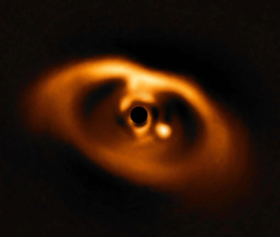 The photo provided by the European Southern Observatory ESO taken from the SPHERE instrument on ESO's Very Large Telescope is the first clear image of a planet caught in the very act of formation around the dwarf star PDS 70. The planet stands clearly out, visible as a bright point to the right of the centre of the image, which is blacked out by the coronagraph mask used to block the blinding light of the central star. (ESO via AP)