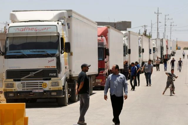 Trucks loaded with humanitarian supplies for displaced Syrians, line up at the Jordanian border. (Reuters)