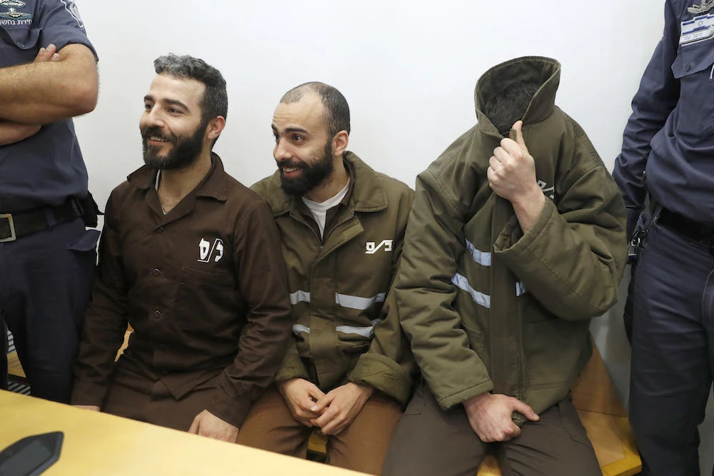 French national Romain Franck (R), 24, a worker at the French consulate, and Palestinians Moufak Al-Ajluni (L) and Mohamed Katout (C) appear in court the southern Israeli city of Beer Sheva on March 19, 2018, to face charges of smuggling guns from Gaza. (AFP)