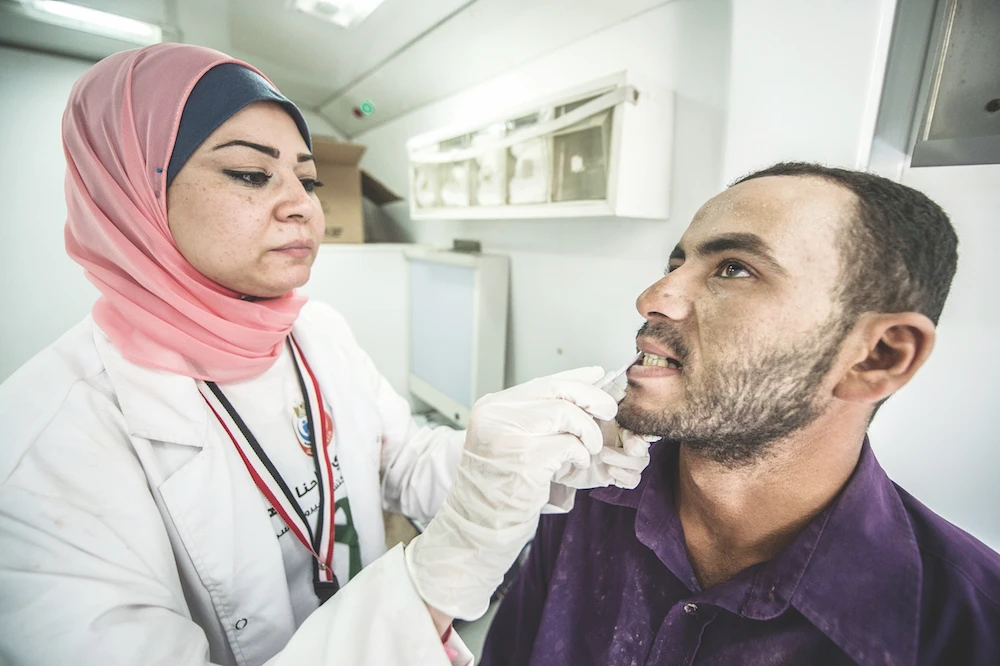 Medical staff take samples from a laborer undergoing examination for Hepatitis C at the construction site near Cairo. (AFP)