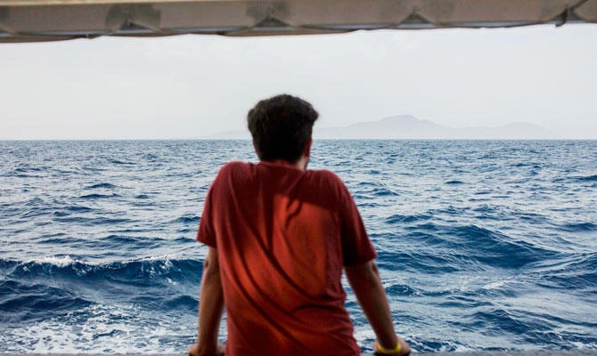 A migrant looks at the sea from the deck of the boat of the NGO Proactiva Open Arms on July 1, 2018. (AFP)