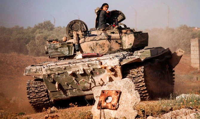 A Syrian rebel fighter rides in a tank near the frontline against government forces west of the embattled southern city of Daraa on Tuesday. (AFP)