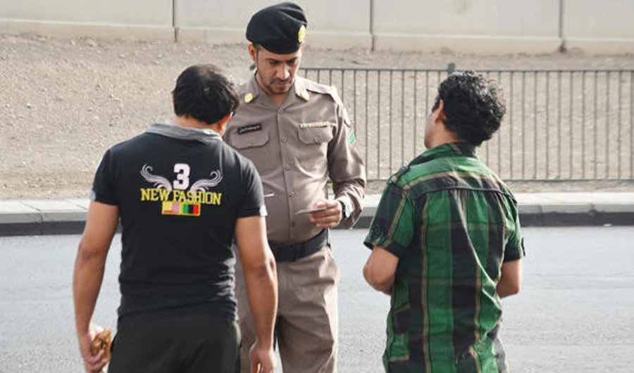 A policeman checks the permits of residents in Saudi Arabia. (AN Photo)