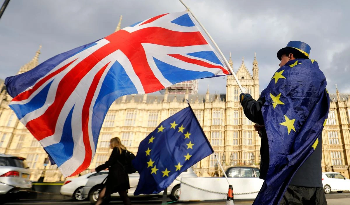 An anti-Brexit demonstrator waves a Union flag alongside an EU flag outside the Houses of Parliament in London. (AFP)