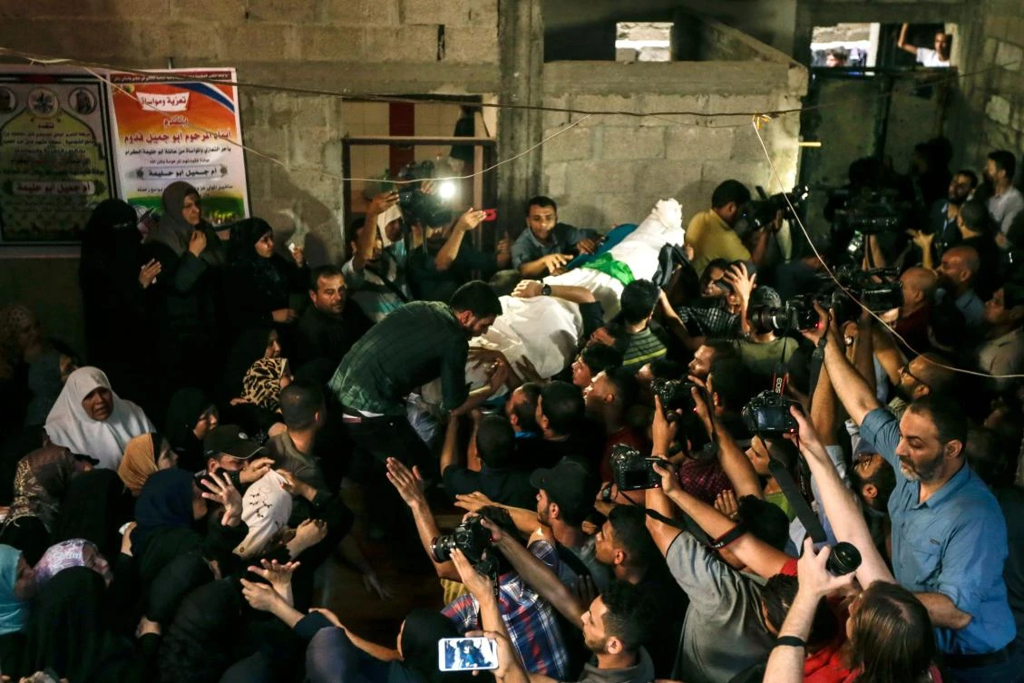 Palestinian mourners carry the body of 22 years old Mohammed abu halima during his funeral in Gaza City on July 7, 2018. (AFP)