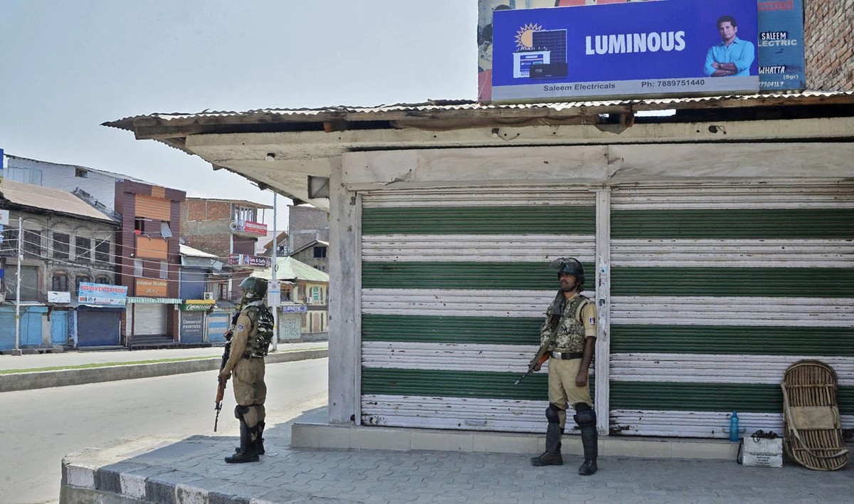 Indian paramilitary troopers stand guard in front of closed shops during a one-day strike in Srinagar on July 8, 2018. (TAUSEEF MUSTAFA/AFP)