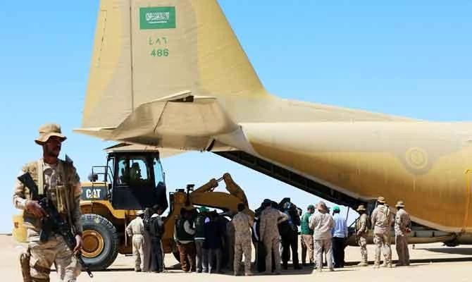 Saudi soldiers stand guard as workers unload aid from a Saudi air force cargo plane at an airfield in Yemen's central province of Marib, in this February 8, 2018 photo. (AFP)