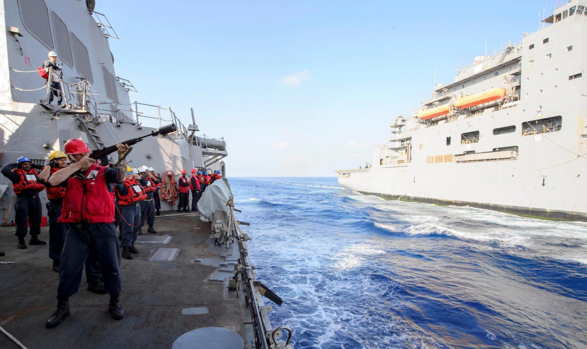 A ship crew fires a shot line from the forward-deployed Arleigh Burke-class guided-missile destroyer Mustin to the Lewis and Clark-class dry cargo ship Matthew Perry, right, during a replenishment-at-sea in the South China Sea on April 4. China has criticized recent US moves to strengthen relations with the administration of Taiwanese President Tsai Ing-wen. (US Navy via Reuters)
