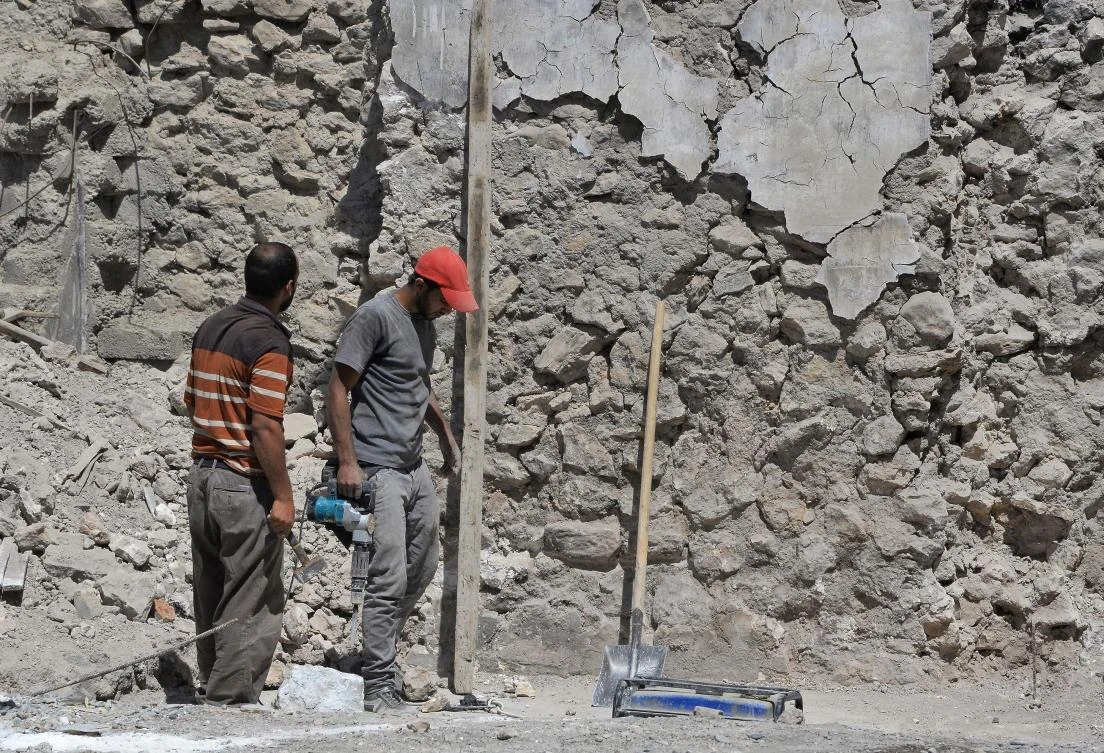Iraqi construction workers rebuild houses in the northern city of Mosul on July 9, 2018. (AFP)