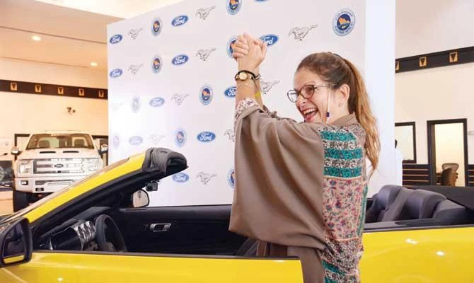 Sahar Nasseif gestures next to her Mustang. AN photo by Huda Bashatah
