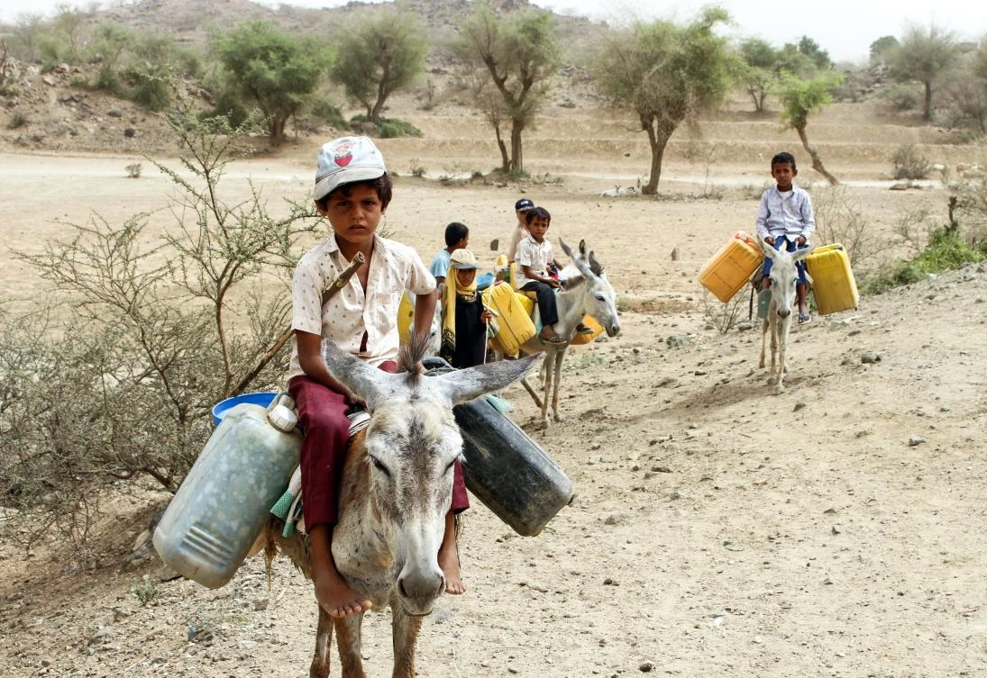 Displaced Yemeni children ride donkeys laden with jerry cans to collect water at a make-shift camp in the northern district of Yemen's Hajjah province on July 7, 2018. (AFP / ESSA AHMED)