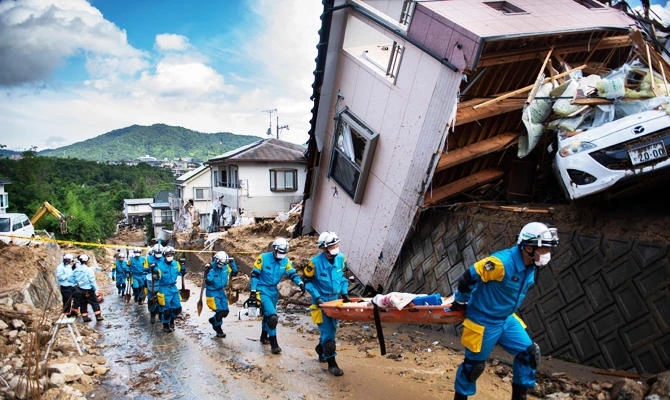 Police arrive to clear debris scattered on a street in a flood hit area in Kumano, Hiroshima prefecture on July 9, 2018. (AFP)