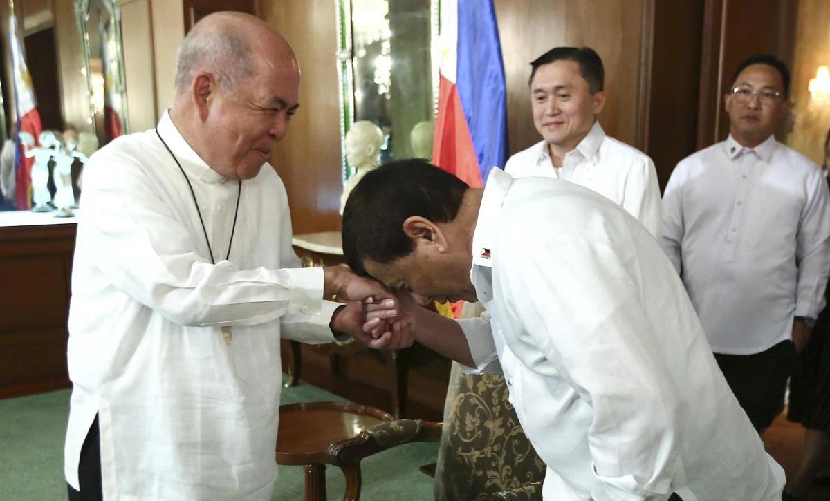 Philippine President Rodrigo Duterte, right, gestures to show respect to Filipino Archbishop Romulo Valles, President of the Catholic Bishops’ Conference of the Philippines, during their meeting at the Malacanang presidential palace in Manila on Monday, July 9. (Malacanang Presidential Photographers Division via AP)