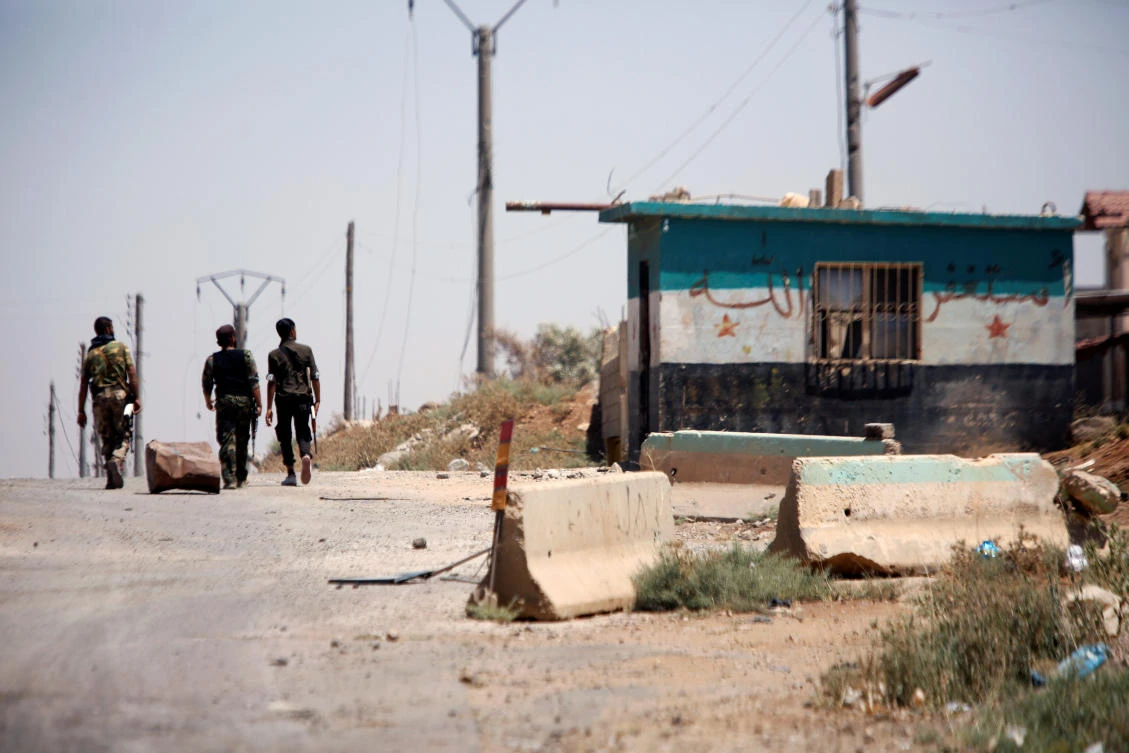 Syrian army soldiers walk along a street in Umm Al-Mayazen, in the countryside of Daraa, Syria, July 10, 2018. (Reuters)