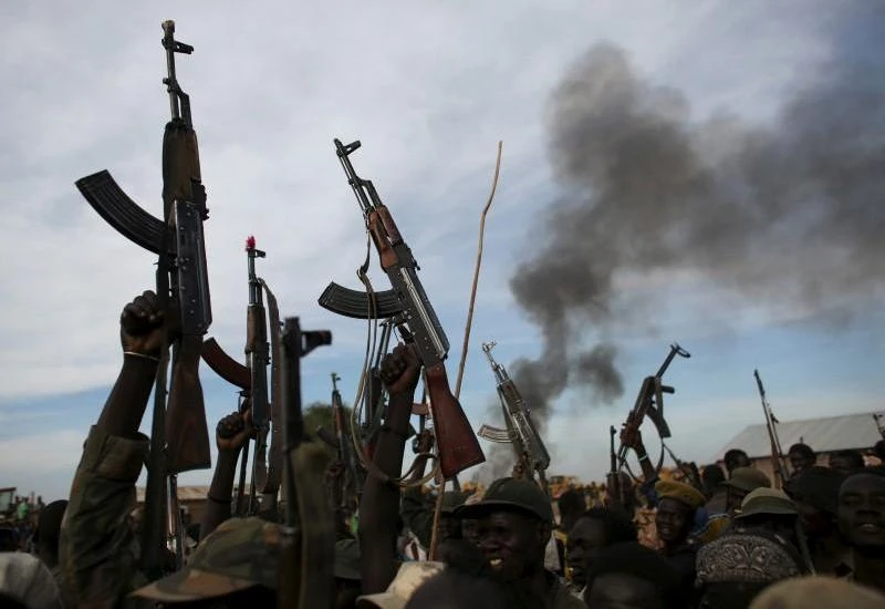 File photo shows rebel fighters hold up their rifles as they walk in front of a bushfire in a rebel-controlled territory in Upper Nile State, South Sudan February 13, 2014. (Reuters)