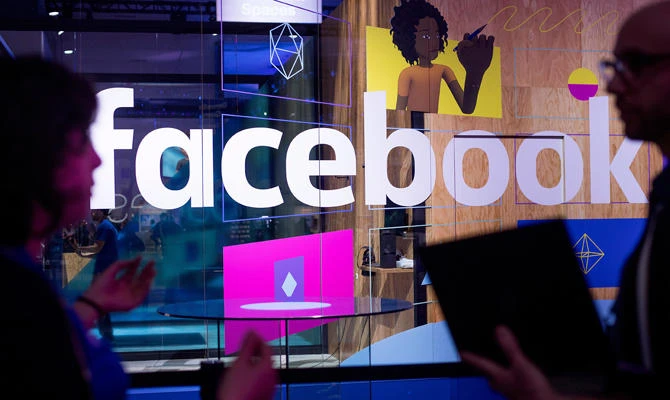 In this April 18, 2017, file photo, conference workers speak in front of a demo booth at Facebook's annual F8 developer conference, in San Jose, Calif. (AP)
