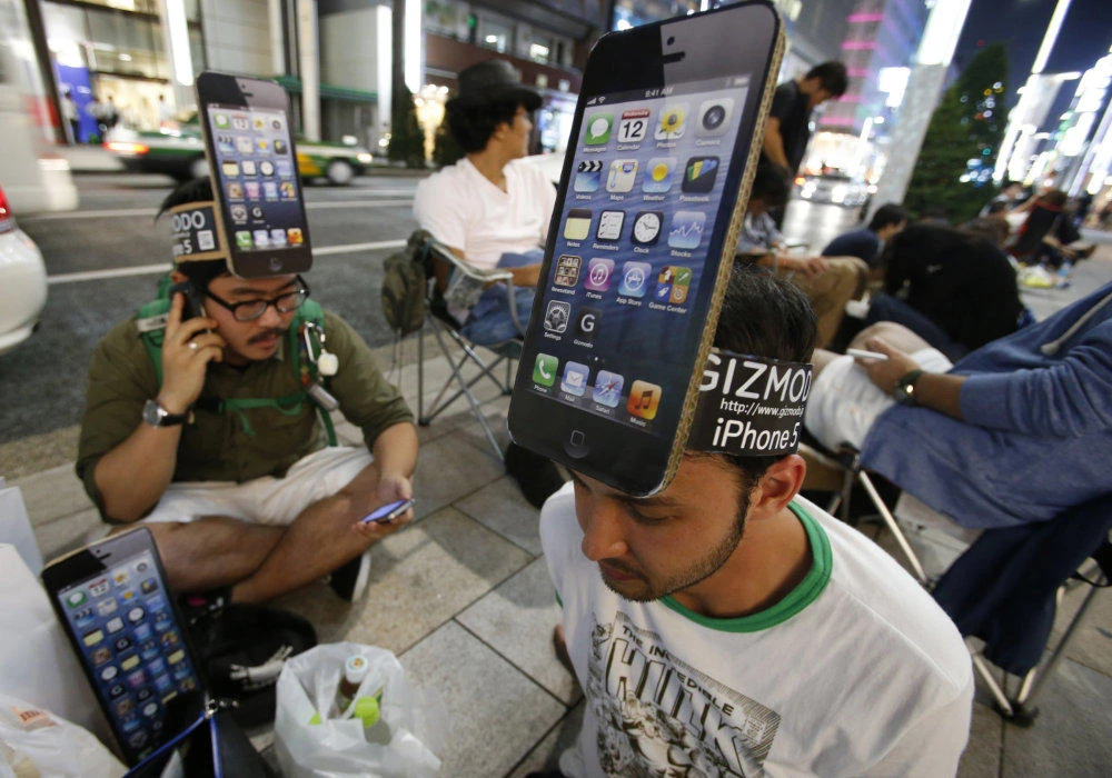 Men wearing cardboard hats, depicting Apple's new iPhone, wait for the release of the phone near Apple Store Ginza in Tokyo. (Reuters)