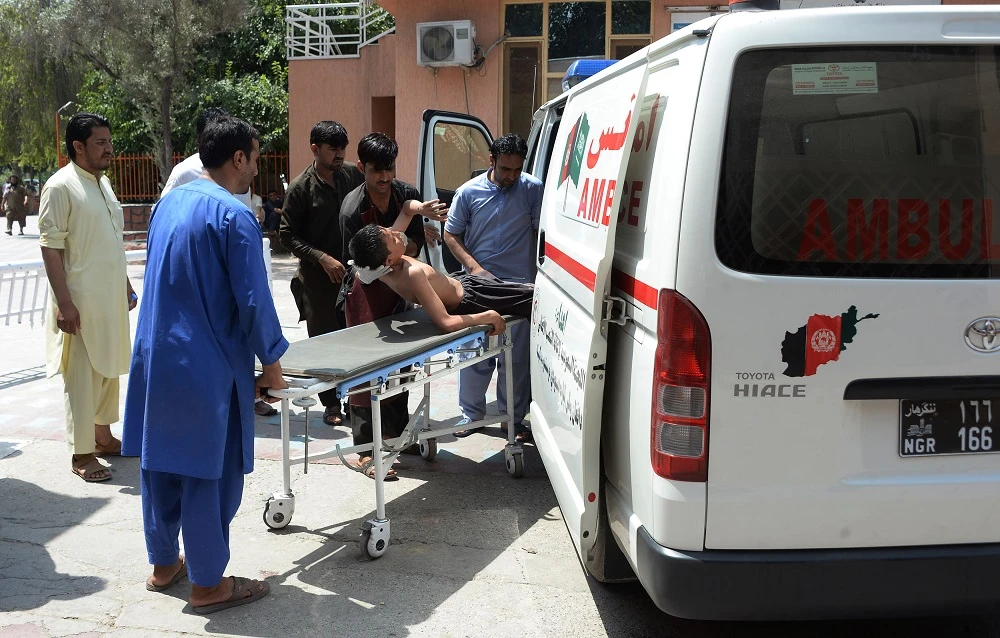 Afghan volunteers carry an injured youth on a stretcher to a hospital following an attack that targeted an education department compound in Jalalabad on Wednesday, July 11. (AFP)