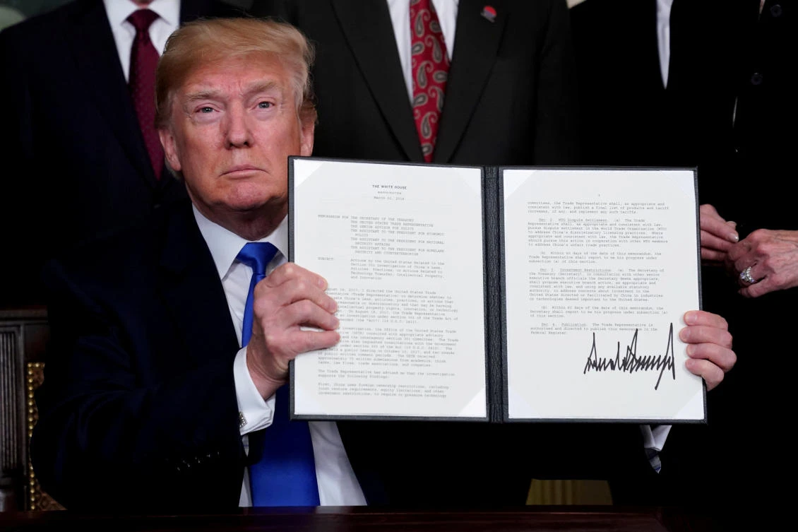 US President Donald Trump holds his signed memorandum on intellectual property tariffs on high-tech goods from China on March 22. Trump has accused China of unfair trade practices that give its firms an advantage, while hobbling American companies and creating an outsized trade deficit for the US. (Reuters)