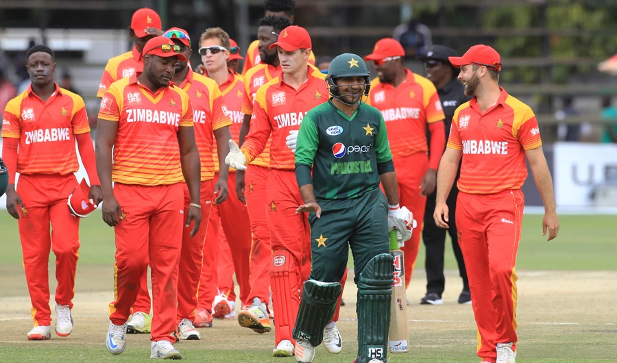 In this file photo, Pakistan captain Sarfraz Ahmed, center, shares a light moment with Zimbabwean players after winning the T20 cricket match at Harare Sports Club, on July 4, 2018. (AP)