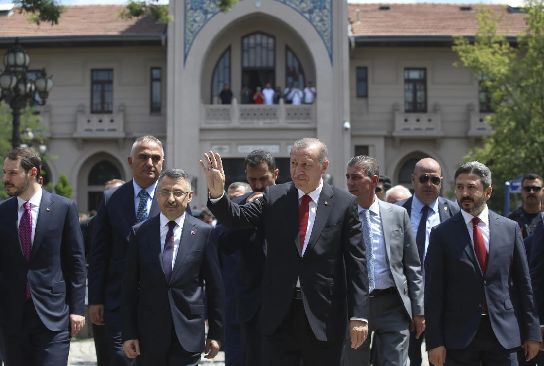 Turkey's President Recep Tayyip Erdogan, center, accompanied by members of his cabinet, salutes supporters during a visit in Ankara, Turkey, Friday, July 13, 2018. (AP)